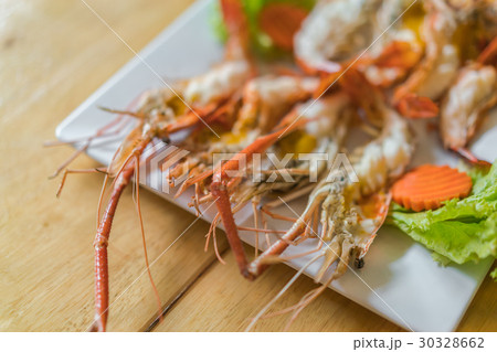 shrimps grilled served in plate on wood table . 30328662