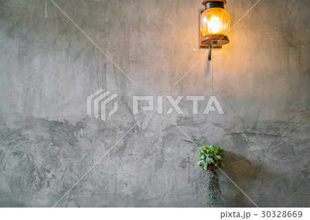 Vintage Lighting decoration with plant over cement wall . 30328669