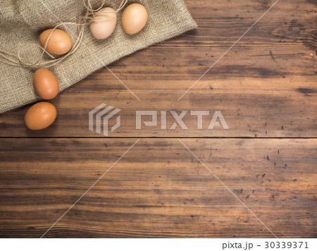 Brown chicken eggs lay on a piece of burlap on a Brown chicken eggs lay on a piece of burlap on a 30339371