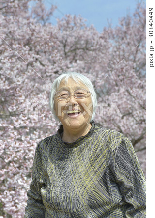 桜を背に笑顔の女性 30340449