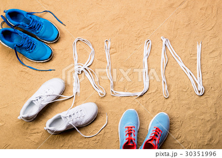 Running shoes and run sign made of shoelaces, sand Running shoes and run sign made of shoelaces, sand 30351996