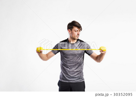 Handsome fitness man working out with rubber band 30352095