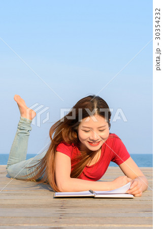 woman lying while reading books 30354232