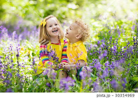 Kids in blooming garden with bluebell flowers Kids in blooming garden with bluebell flowers 30354969