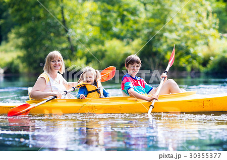 Family enjoying kayak ride on a river 30355377