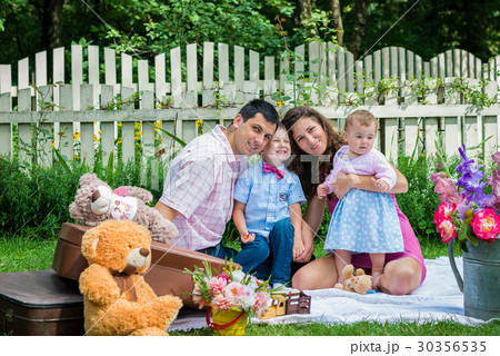 A couple sitting with the children A couple sitting with the children 30356535