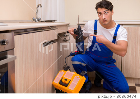 Young repairman working at the kitchen 30360474