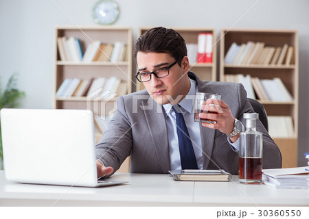 Businessman drinking in the office Businessman drinking in the office 30360550