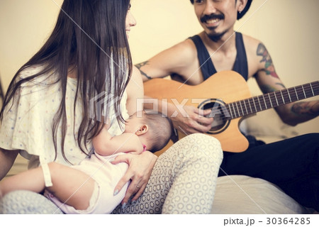 Father and mother are taking care of their child. 30364285