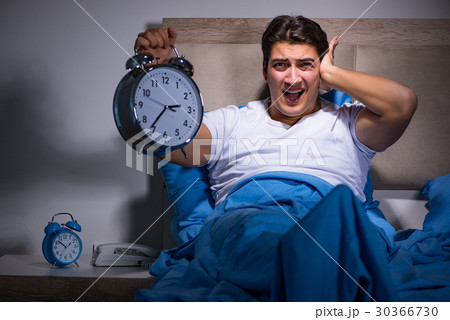 Man having trouble sleeping in bed 30366730