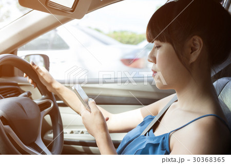 woman driver using a smart phone in car woman driver using a smart phone in car 30368365