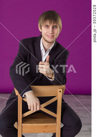 businessman sitting on a bar stool and shows class businessman sitting on a bar stool and shows class 30372028