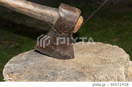 Old axe on a tree stump for chopping firewood. 30372416