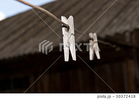 Old wooden clothespins for linen on the wire. 30372418