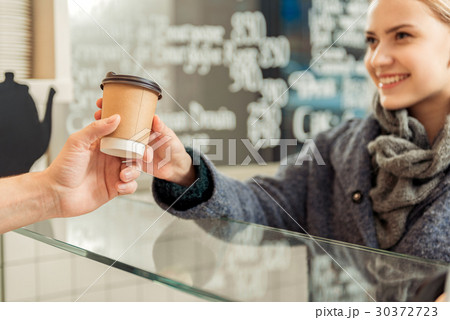 Joyful woman buying espresso in cafeteria 30372723