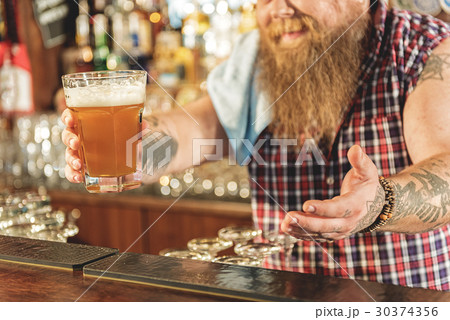 Man hand holding out drinks in pub 30374356