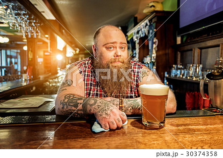 Pensive bearded man standing in tap-room 30374358