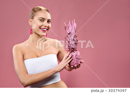 Happy positive girl showing pink ananas 30374397