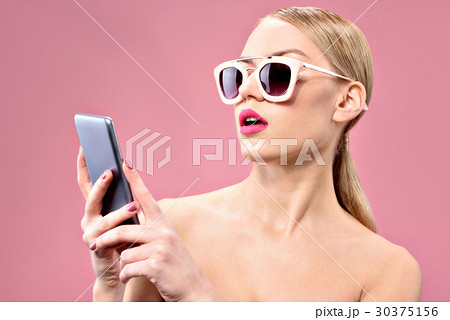 Attractive young woman looking at mobile screen Attractive young woman looking at mobile screen 30375156