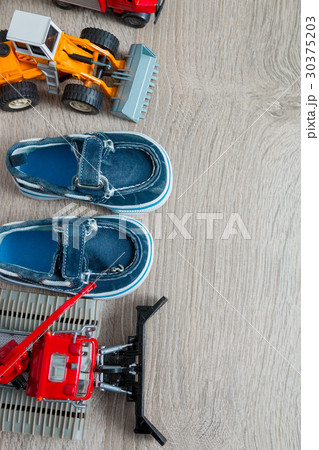 Blue boat shoes for boy near set of car toy 30375203