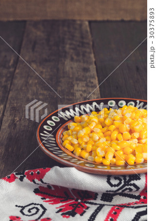 Canned corn in a brown bowl on wooden 30375893