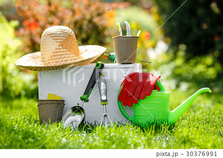 Gardening tools and a straw hat on the grass in Gardening tools and a straw hat on the grass in 30376991