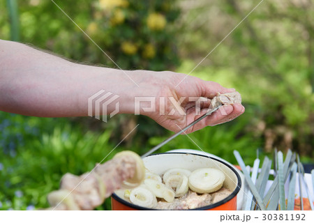 Man stringing meat on a skewer Man stringing meat on a skewer 30381192
