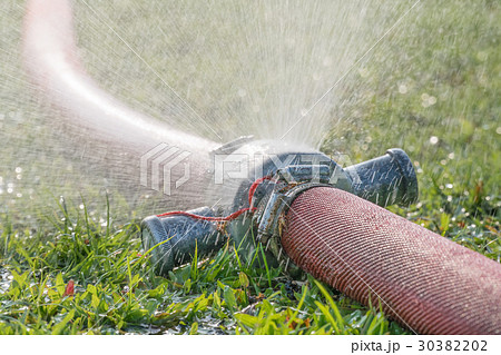 water leaking from hole in a industrial hose. 30382202