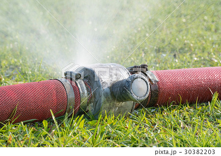 water leaking from hole in a industrial hose. 30382203
