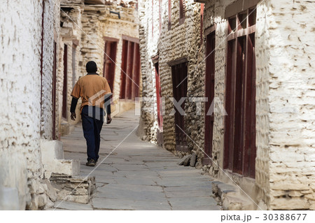 The man walking on the street near rural residence 30388677