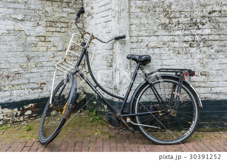 Old bicycle against a Wall 30391252