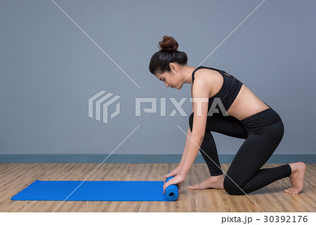 Young asian woman preparing yoga mat for yoga 30392176