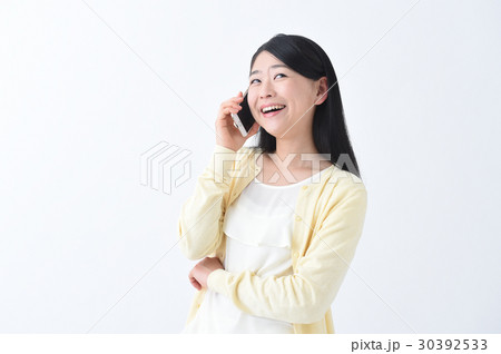 大笑い 電話で話しながら爆笑する若い女性の写真素材
