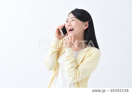 大笑い 電話で話しながら爆笑する若い女性の写真素材