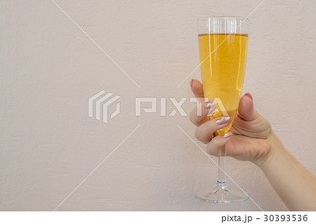 Woman holds wine glass on beige background 30393536