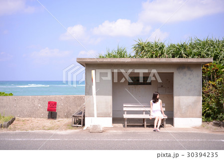 海辺のバス停留所でバスを待つ若い女性 海辺のバス停留所でバスを待つ若い女性 30394235
