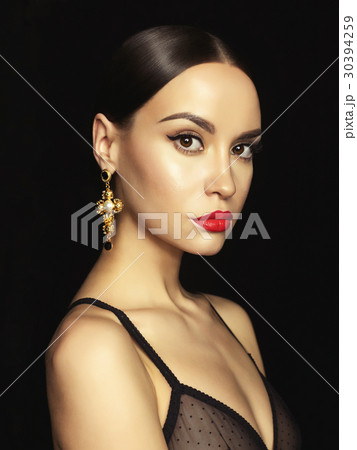 Beautiful lady with earring on black background Beautiful lady with earring on black background 30394259
