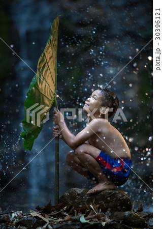 The boy joyful playing water splash in waterfall 30396121