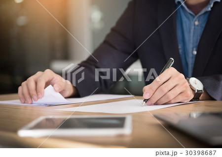 Businessman writing in a document. Focus on the tip of the pen Businessman writing in a document. Focus on the tip of the pen 30398687
