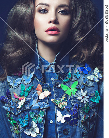 Young woman in jeans with a lot of brooches Young woman in jeans with a lot of brooches 30398803