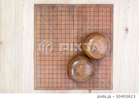 two wooden bowls over empty go game board 30403623