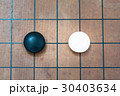 white stone approach to black stone on go game board 30403634