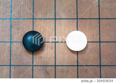 white stone approach to black stone on go game board 30403634