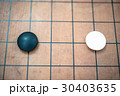 white stone approach to black stone on go game board 30403635