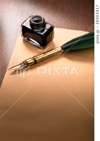 Quill pen and paper on wooden table 30403917