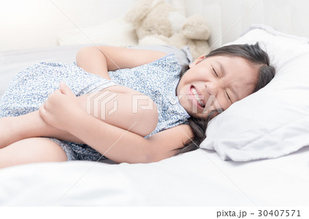 asian girl feeling stomachache pain on bed, 30407571