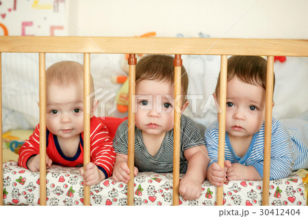 Portrait of newborn triplets in the bed Portrait of newborn triplets in the bed 30412404