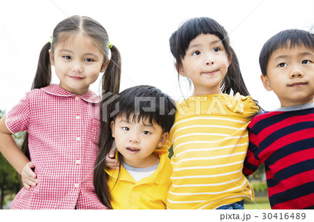 Group of smiling kids standing outside together Group of smiling kids standing outside together 30416489