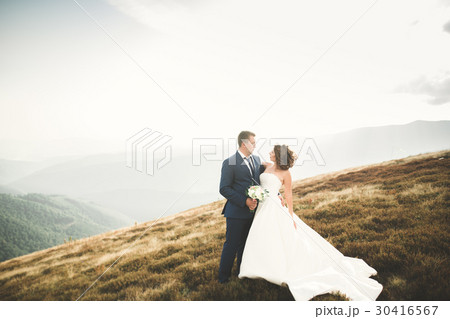 Beautiful wedding couple posing on top of a 30416567