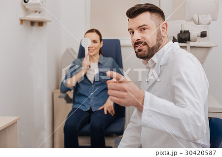 Delighted pleasant doctor pointing at the eye Delighted pleasant doctor pointing at the eye 30420587